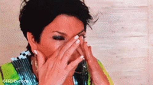 A Close Up Of A Woman Covering Her Face With Her Hands . GIF