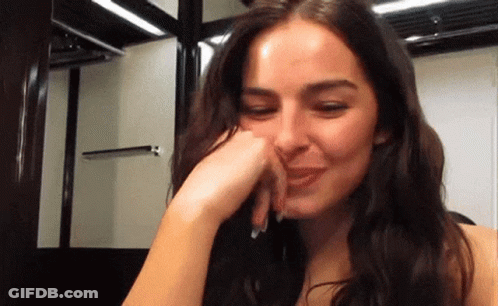 A Close Up Of A Woman Covering Her Mouth With Her Hand GIF