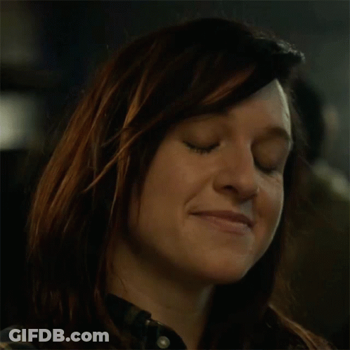 A Close Up Of A Woman Drinking From A Bottle In A Dark Room GIF