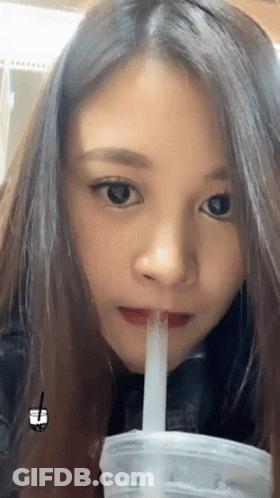 A Close Up Of A Woman Drinking From A Plastic Cup With A Straw GIF