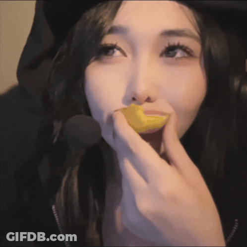 A Close Up Of A Woman Eating A Yellow Object GIF