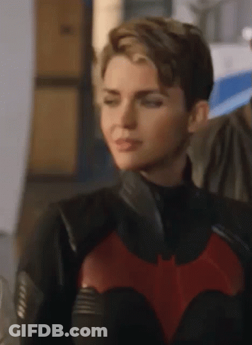 A Close Up Of A Woman In A Batman Costume . GIF