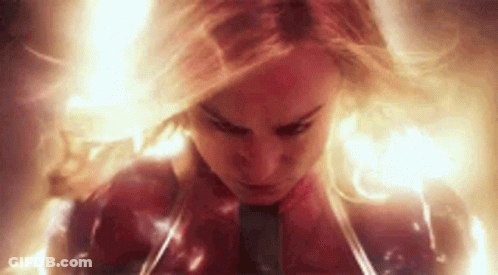 A Close Up Of A Woman In A Superhero Costume Surrounded By Flames . GIF