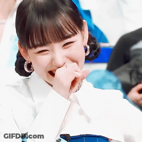 A Close Up Of A Woman Laughing With Her Hand To Her Mouth . GIF