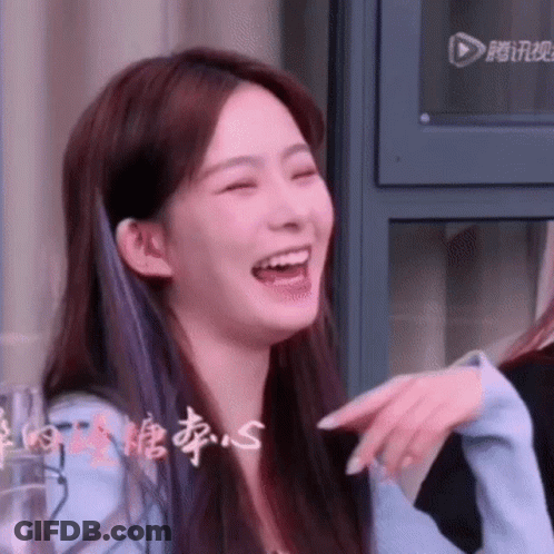 A Close Up Of A Woman Laughing With Her Mouth Open And Pointing At Something . GIF