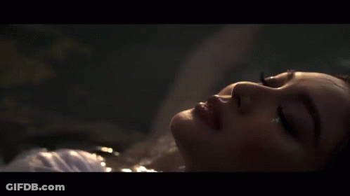 A Close Up Of A Woman Laying In The Water GIF