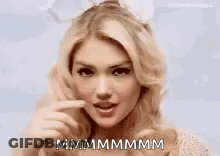 A Close Up Of A Woman Making A Funny Face And Pointing At Her Mouth . GIF