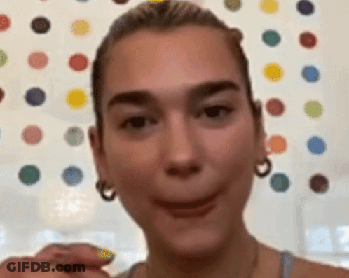 A Close Up Of A Woman Making A Funny Face In Front Of A Wall With Polka Dots . GIF