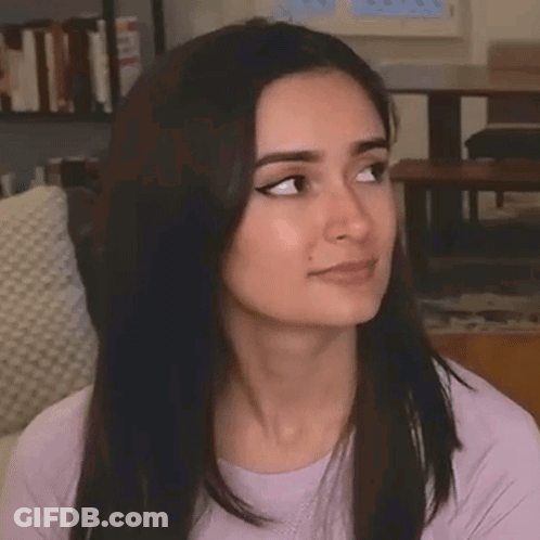 A Close Up Of A Woman Making A Funny Face While Sitting On A Couch In A Living Room . GIF