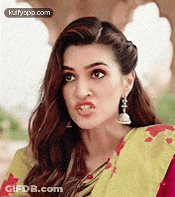 A Close Up Of A Woman Making A Funny Face While Wearing A Saree And Earrings . GIF