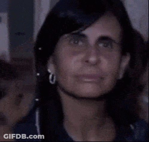 A Close Up Of A Woman Making A Funny Face While Wearing Ear Buds . GIF