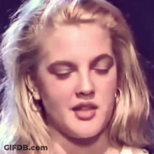 A Close Up Of A Woman Making A Funny Face With Her Eyes Closed . GIF