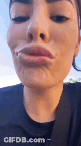 A Close Up Of A Woman Making A Funny Face With Her Eyes Closed . GIF