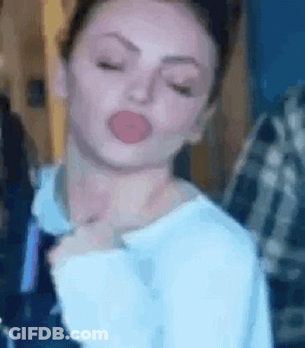 A Close Up Of A Woman Making A Funny Face With Her Eyes Closed And Her Tongue Out . GIF