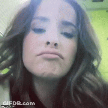 A Close Up Of A Woman Making A Funny Face With Her Eyes Closed . GIF