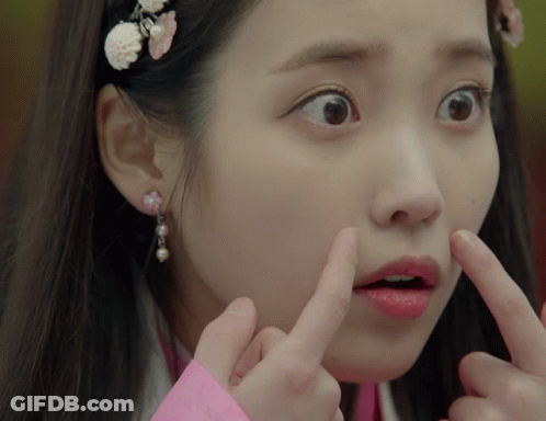 A Close Up Of A Woman Making A Funny Face With Her Fingers GIF