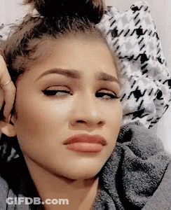 A Close Up Of A Woman Making A Funny Face With Her Hand On Her Ear . GIF
