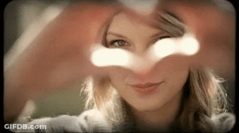 A Close Up Of A Woman Making A Heart Shape With Her Hands GIF