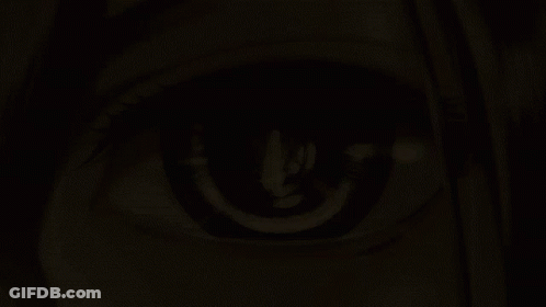 A Close Up Of A Woman 'S Eye With A Candle Reflection In It GIF