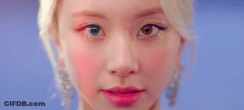 A Close Up Of A Woman 'S Eye With Glitter On It And A Red Background . GIF