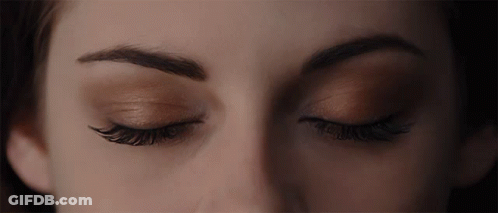 A Close Up Of A Woman 'S Eyes With A Dark Background GIF