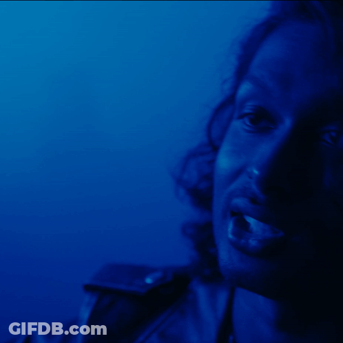 A Close Up Of A Woman 'S Face Against A Blue Background GIF