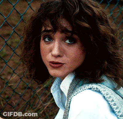 A Close Up Of A Woman 'S Face Against A Chain Link Fence GIF