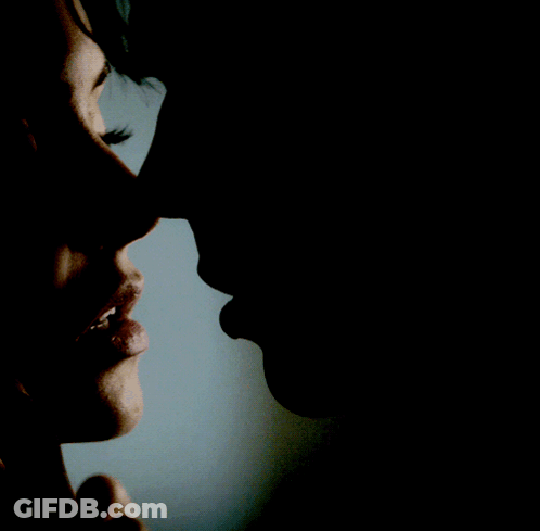 A Close Up Of A Woman 'S Face And A Man 'S Face In The Dark GIF