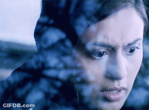 A Close Up Of A Woman 'S Face Behind A Glass GIF