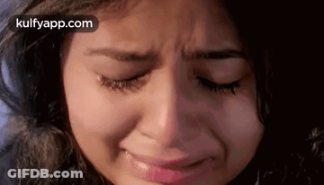 A Close Up Of A Woman 'S Face Crying With Her Eyes Closed . GIF