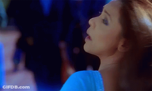 A Close Up Of A Woman 'S Face In A Blue Top GIF