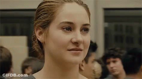 A Close Up Of A Woman 'S Face In A Crowded Room . GIF