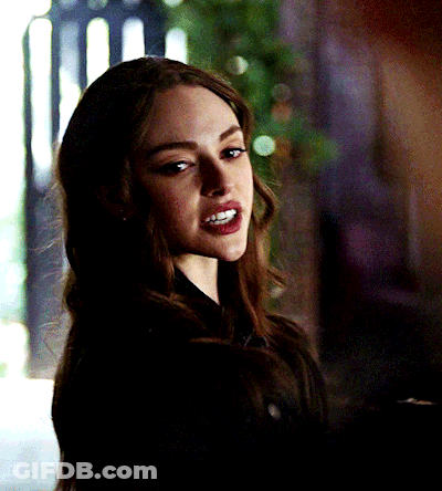 A Close Up Of A Woman 'S Face In A Dark Room GIF
