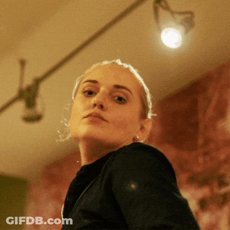 A Close Up Of A Woman 'S Face In A Dark Room GIF