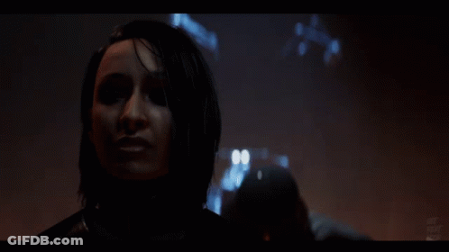 A Close Up Of A Woman 'S Face In A Dark Room With A Blurred Background GIF