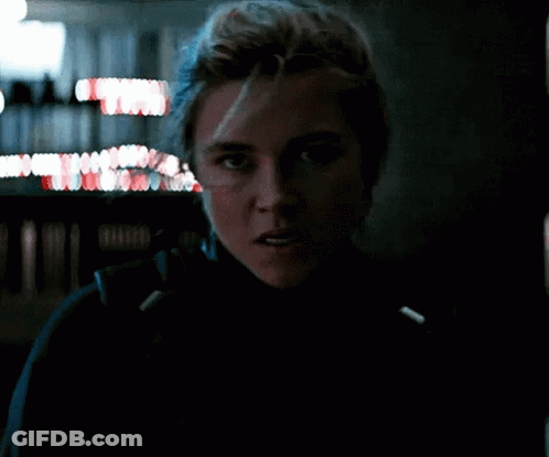 A Close Up Of A Woman 'S Face In A Dark Room With A Blurry Background . GIF