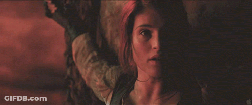 A Close Up Of A Woman 'S Face In A Dark Room With An Apple Logo In The Corner GIF