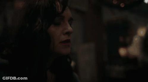 A Close Up Of A Woman 'S Face In A Dark Room With Her Eyes Closed . GIF