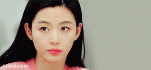 A Close Up Of A Woman 'S Face In A Pink Shirt GIF