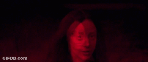 A Close Up Of A Woman 'S Face In A Red Light GIF
