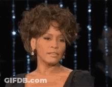 A Close Up Of A Woman 'S Face In Front Of A Black Background . GIF