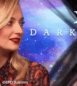 A Close Up Of A Woman 'S Face In Front Of A Blue Background With The Word Dark Written On It . GIF