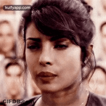 A Close Up Of A Woman 'S Face In Front Of A Crowd . GIF