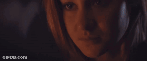 A Close Up Of A Woman 'S Face In The Dark GIF