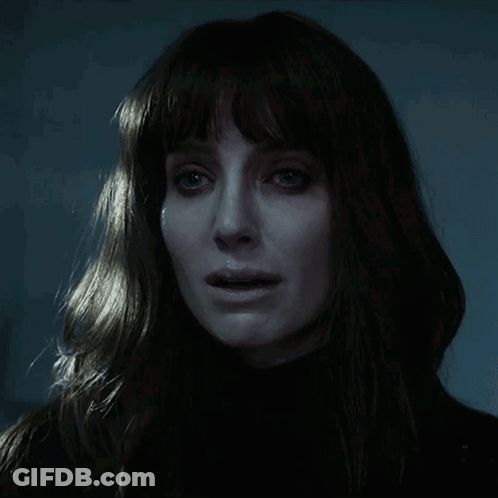A Close Up Of A Woman 'S Face In The Dark GIF