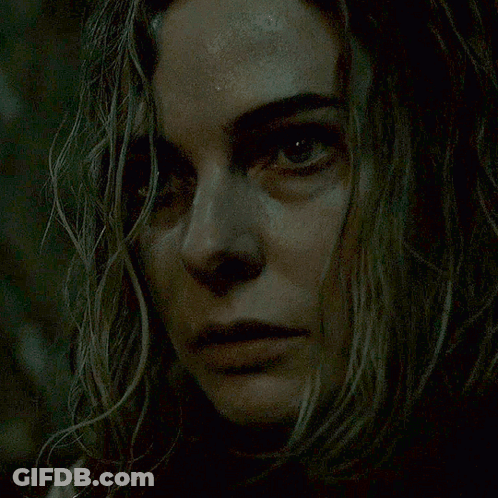 A Close Up Of A Woman 'S Face In The Dark GIF