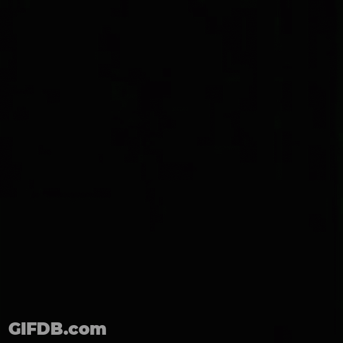 A Close Up Of A Woman 'S Face In The Dark . GIF