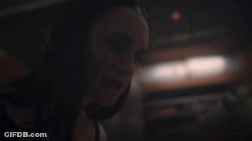 A Close Up Of A Woman 'S Face In The Dark GIF