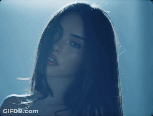 A Close Up Of A Woman 'S Face In The Dark GIF
