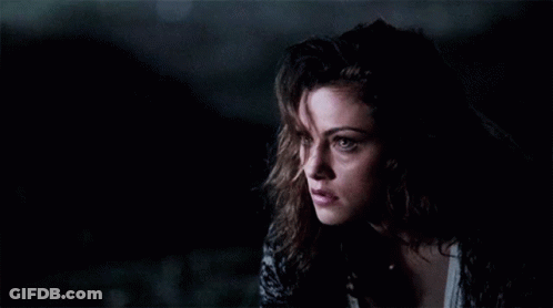 A Close Up Of A Woman 'S Face In The Dark GIF